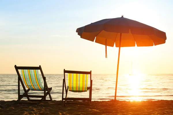 Paire de chaises longues sur la côte déserte mer au lever du soleil — Photo