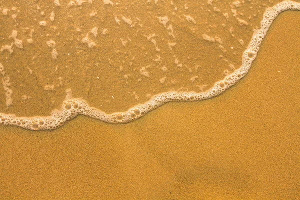 Onda suave del mar, textura de arena de playa . — Foto de Stock