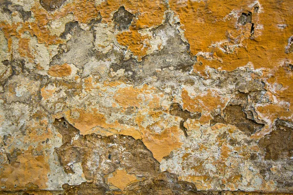 Texturfarbe auf einem bröckelnden alten Stucksteinhaus. — Stockfoto