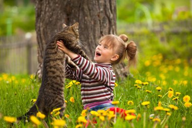 bir kedi ile oynarken sevimli küçük kız