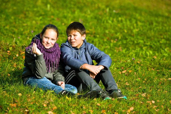 Genç çift sonbahar parkta oturmak — Stok fotoğraf