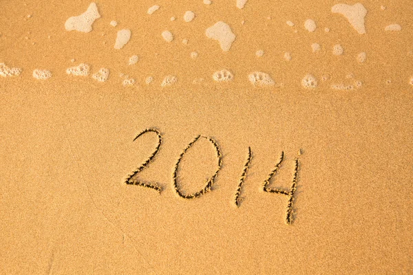 2014 - escrito em areia na textura da praia, onda suave do mar — Fotografia de Stock