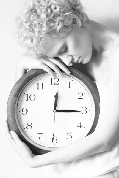 Conceptual portrait of woman in bed with big clock — Stock Photo, Image