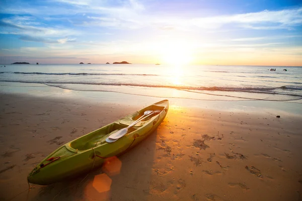 Kajak am tropischen Strand bei schönem Sonnenuntergang. — Stockfoto