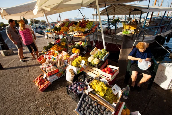 An unidentified seller in market on waterfront — Stock Photo, Image