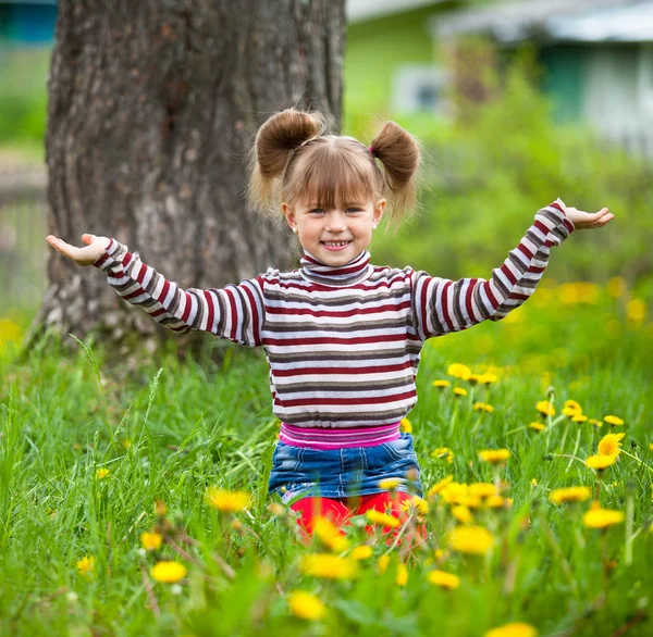 Bella bambina di cinque anni seduta sull'erba . — Foto Stock