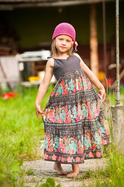 Linda menina de cinco anos posando para a câmera no quintal de uma casa de aldeia . — Fotografia de Stock