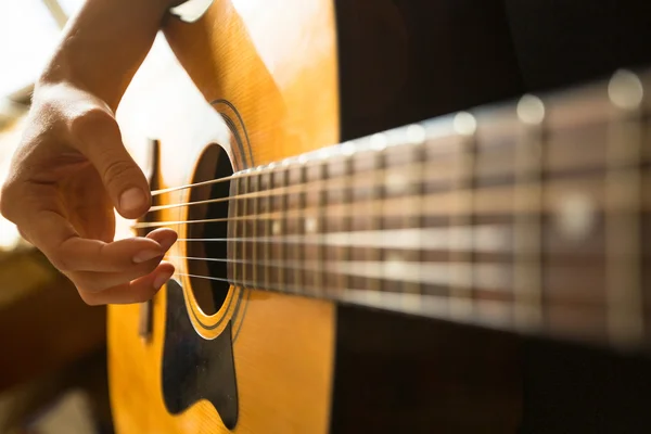 Primer plano mano femenina tocando en la guitarra acústica — Foto de Stock
