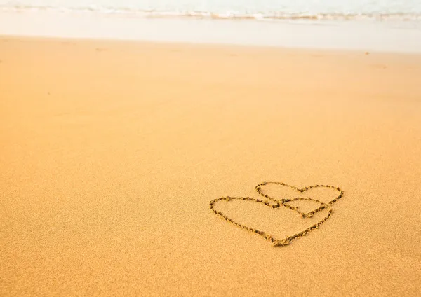 Два сердца на пляже — стоковое фото