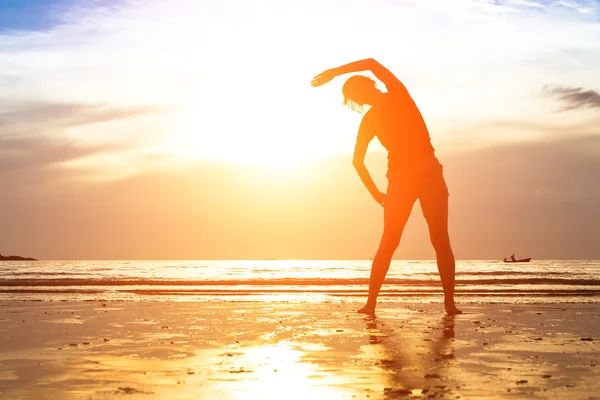 Kvinna övningar på stranden — Stockfoto