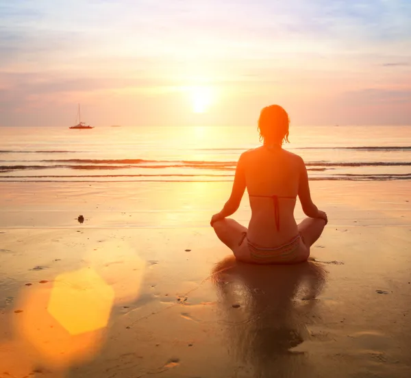 Vrouw yoga op zee zonsondergang — Stockfoto