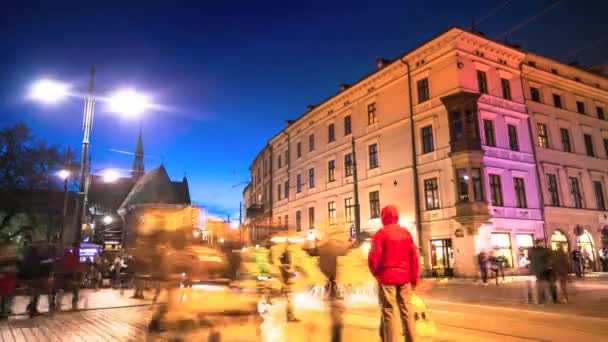 Перекресток на оживленной улице в центре Кракова в ночное время — стоковое видео