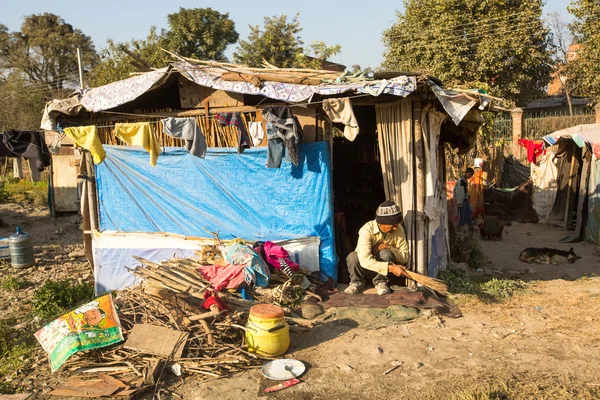 Αγνώστων στοιχείων φτωχοί άνθρωποι κοντά τα σπίτια τους σε φτωχογειτονιές — Φωτογραφία Αρχείου
