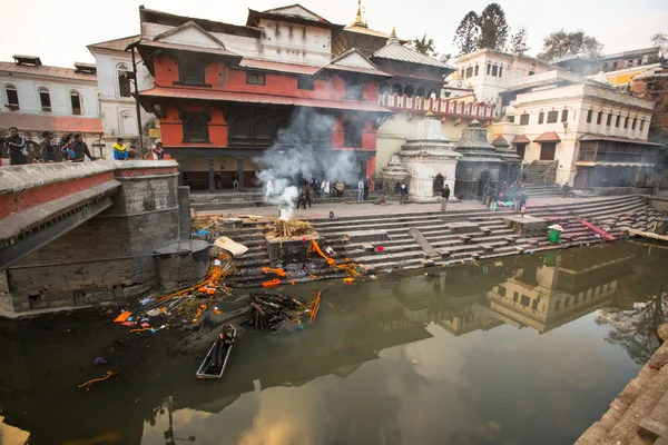 Under kremering ceremonin längs floden heliga bagmati — Stockfoto