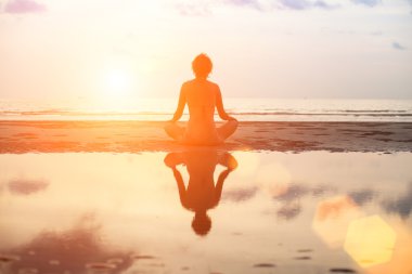 Lotus poz sahilde oturup yoga kadın