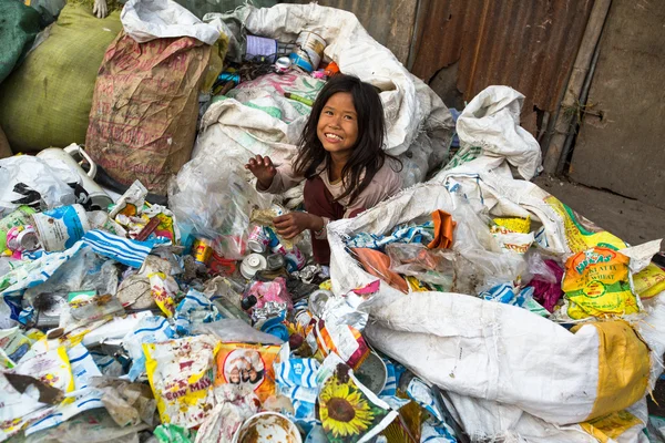 Unbekanntes Kind sitzt während seine Eltern auf Müllkippe arbeiten — Stockfoto