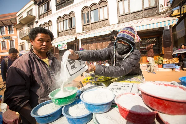 Uomo non identificato vende cemento per donazioni per riparazioni vicino stupa Boudhanath — Foto Stock