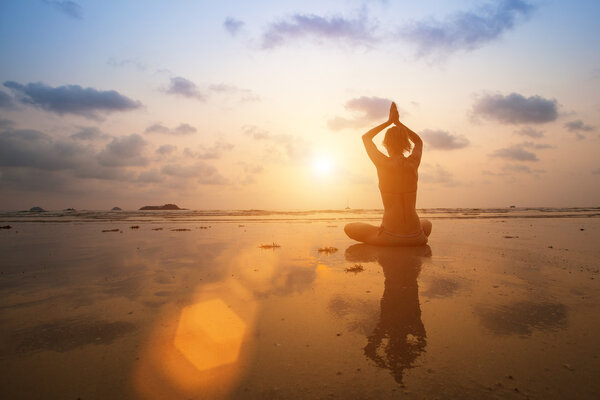 Силуэт Молодая женщина практикующая йогу