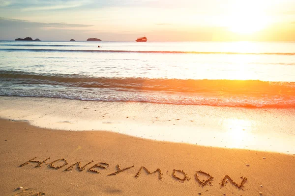 Lua de mel a inscrição na areia da praia . Imagem De Stock