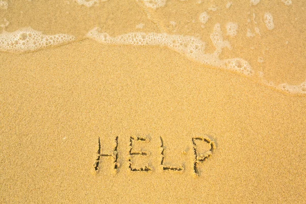 Help, written in sand on beach texture Royalty Free Stock Photos