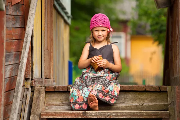 Hermosa niña de cinco años en el porche de una casa de pueblo — Foto de Stock