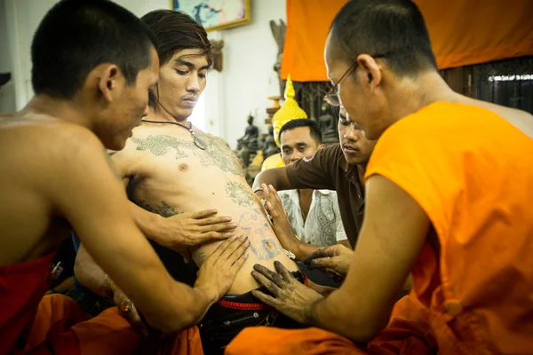 Oidentifierade munk gör traditionella yantra tatuera under wai kroo master day ceremoni i wat bang pra — Stockfoto