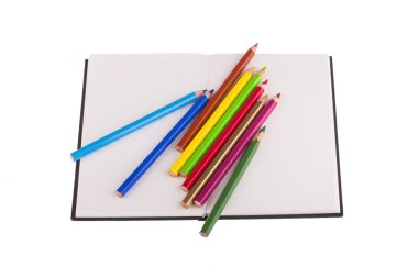 defter üzerinde yerleştirilen renkli kalemler