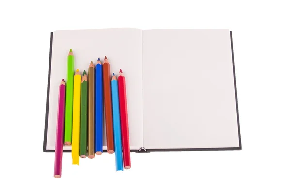 Crayons de couleur placés sur le carnet — Photo