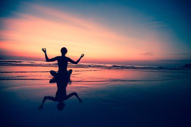 Deniz kıyısında oturan yoga kadın