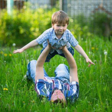 Baba ve oğul çimenlerde oynama.