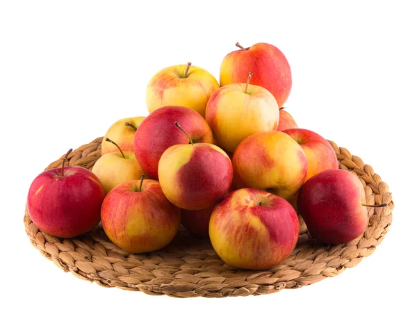 Red and yellow apples on a straw mat — Stock Photo, Image