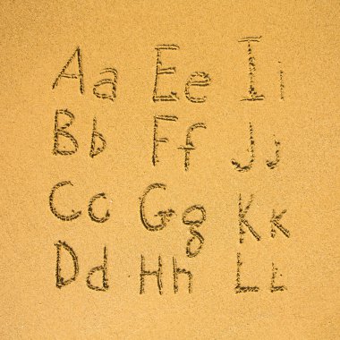 bir kum plajı üzerinde yazılı alfabesi