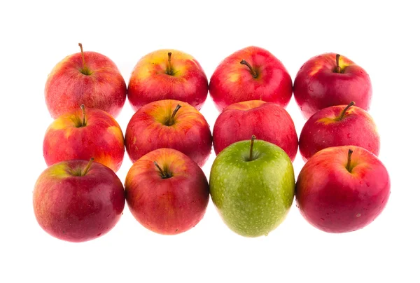 Green apple among red apples — Stock Photo, Image