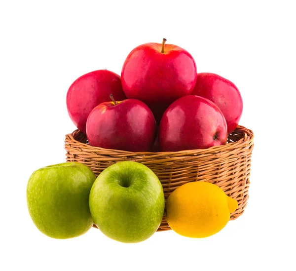 Červená a zelená jablka a citrón v dřevěné koše — Stock fotografie