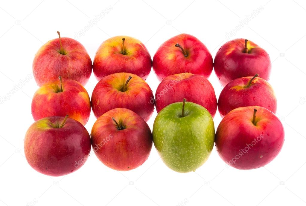 Green apple among red apples
