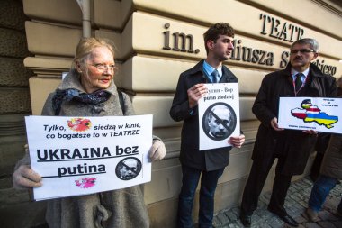 Krakow, Polonya - mar 9, 2014: kimliği belirsiz katılımcıları karşı Kırım ' Rus askerlerinin getirerek cracow opera yakınındaki protesto sırasında. Posterler: Ukrayna putin ve putin - hırsız.