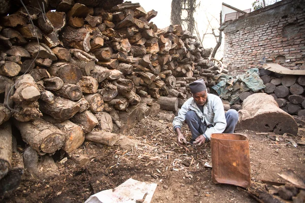 Unidentified man sort wood for cremation — Stock Photo, Image