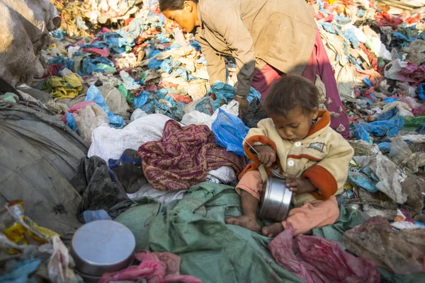 Niet-geïdentificeerde kind zit terwijl haar ouders bezig bent dump — Stockfoto
