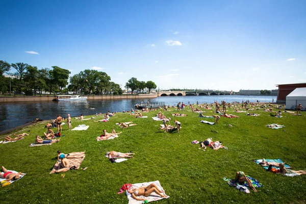 Unidentified people sunbathe on the beach the Peter and Paul Fortress — Stock Photo, Image
