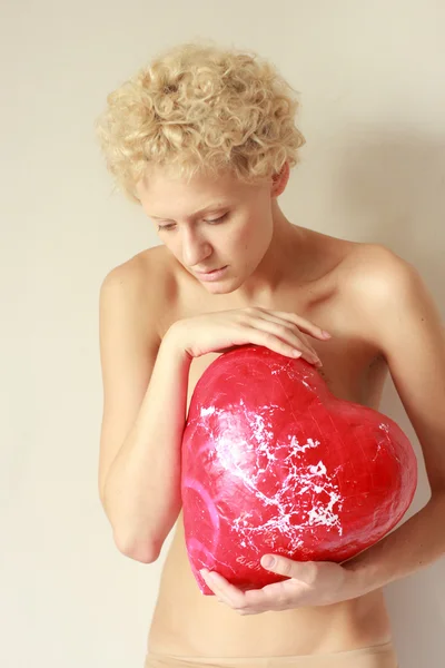 Sensual young woman with a big toy heart — Stock Photo, Image