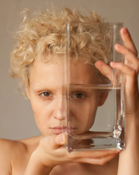 Young girl looks through the empty glass. — Stock Photo, Image