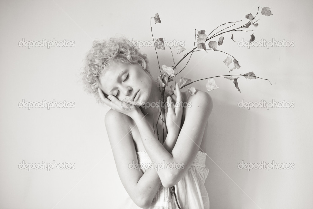 Young scrawny sexy girl with a dry twig in hands