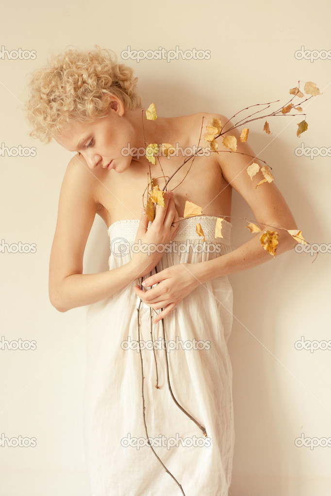 Young scrawny sexy girl with a dry twig in hands