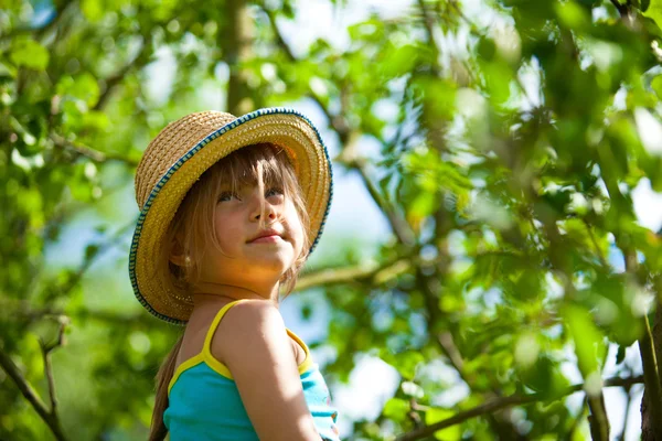 Niña posando en un sombrero de paja en el parque . — Foto de Stock