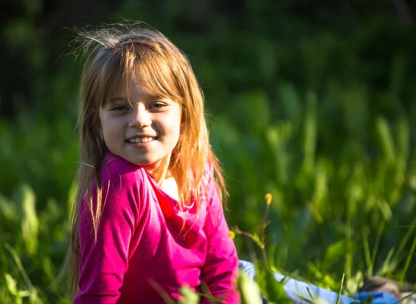 微笑在草丛中的小女孩 — 图库照片