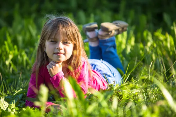 Leende liten flicka i gräs — Stockfoto