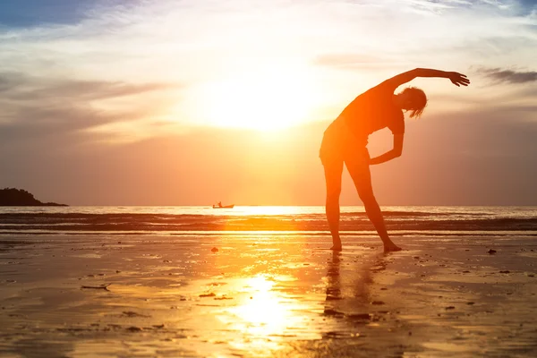 Fille pratiquant le yoga au coucher du soleil . — Photo