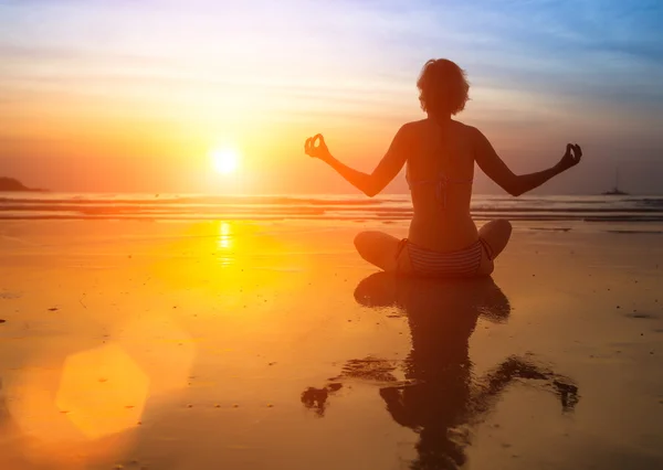 Mujer yoga sentada en la costa del mar —  Fotos de Stock