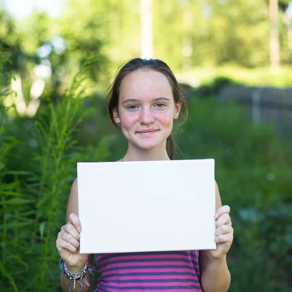 Mädchen hält sauberes weißes Papier — Stockfoto