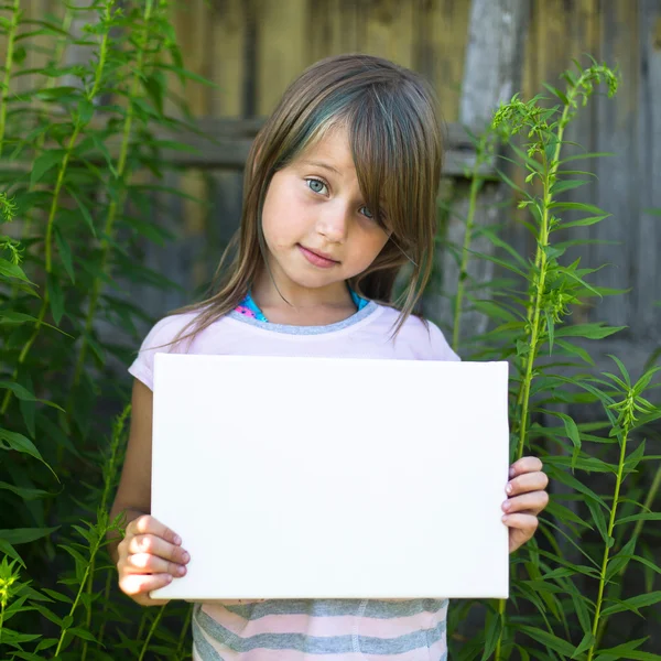 Menina segurando papel branco limpo — Fotografia de Stock